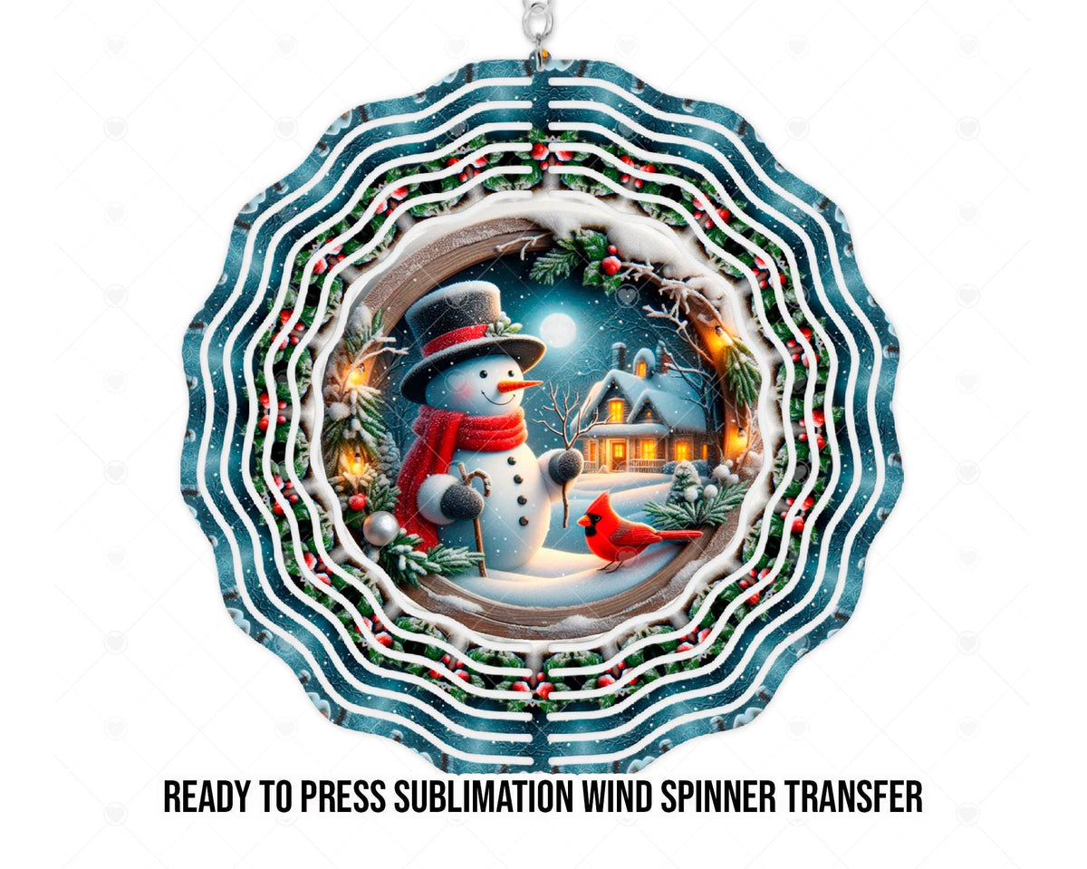 Wind spinner mockup displaying artwork for a printed sublimation transfer: a smiling snowman wearing a black top hat and red scarf beside a red cardinal in the snow. A full moon shines above a snowy cottage with glowing windows. Snow-covered greenery, red berries, and a circular wood-look frame surround the scene, with teal scalloped rings extending outward.